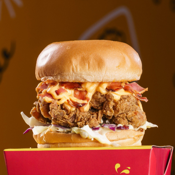 Experimente nosso sanduíche de frango crocante, feito com peito de frango empanado e frito, servido em um pão brioche macio. Acompanha molho especial, salada coleslaw fresca, queijo cheddar derretido e bacon crocante, oferecendo uma explosão de sabor.