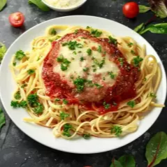 Espaguete al dente envolvido em molho de tomate artesanal, acompanhado de suculento filé de frango empanado, coberto com queijo derretido e finalizado com um toque especial de ervas.