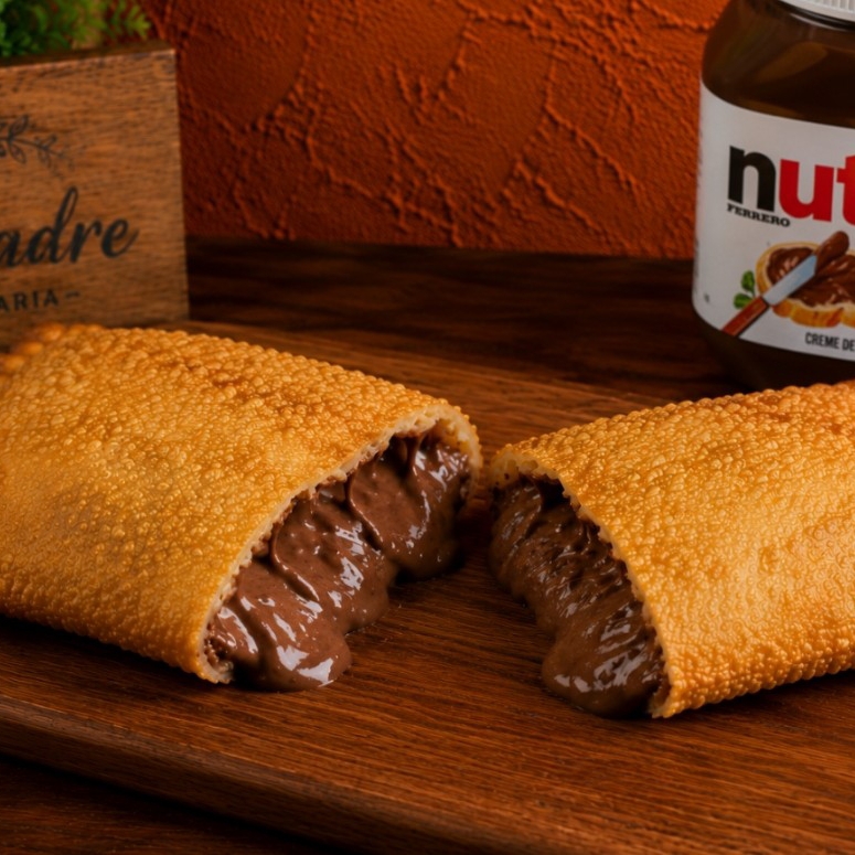 Deixe-se levar por uma experiência indulgente com nosso pastel de Nutella, uma verdadeira tentação para os amantes de chocolate! Cada mordida é uma explosão de sabor, com a cremosidade irresistível da Nutella envolta em uma massa delicadamente crocante. #doce #pastel #Nutella #doce #massa #chocolate Imagem meramente ilustrativa!