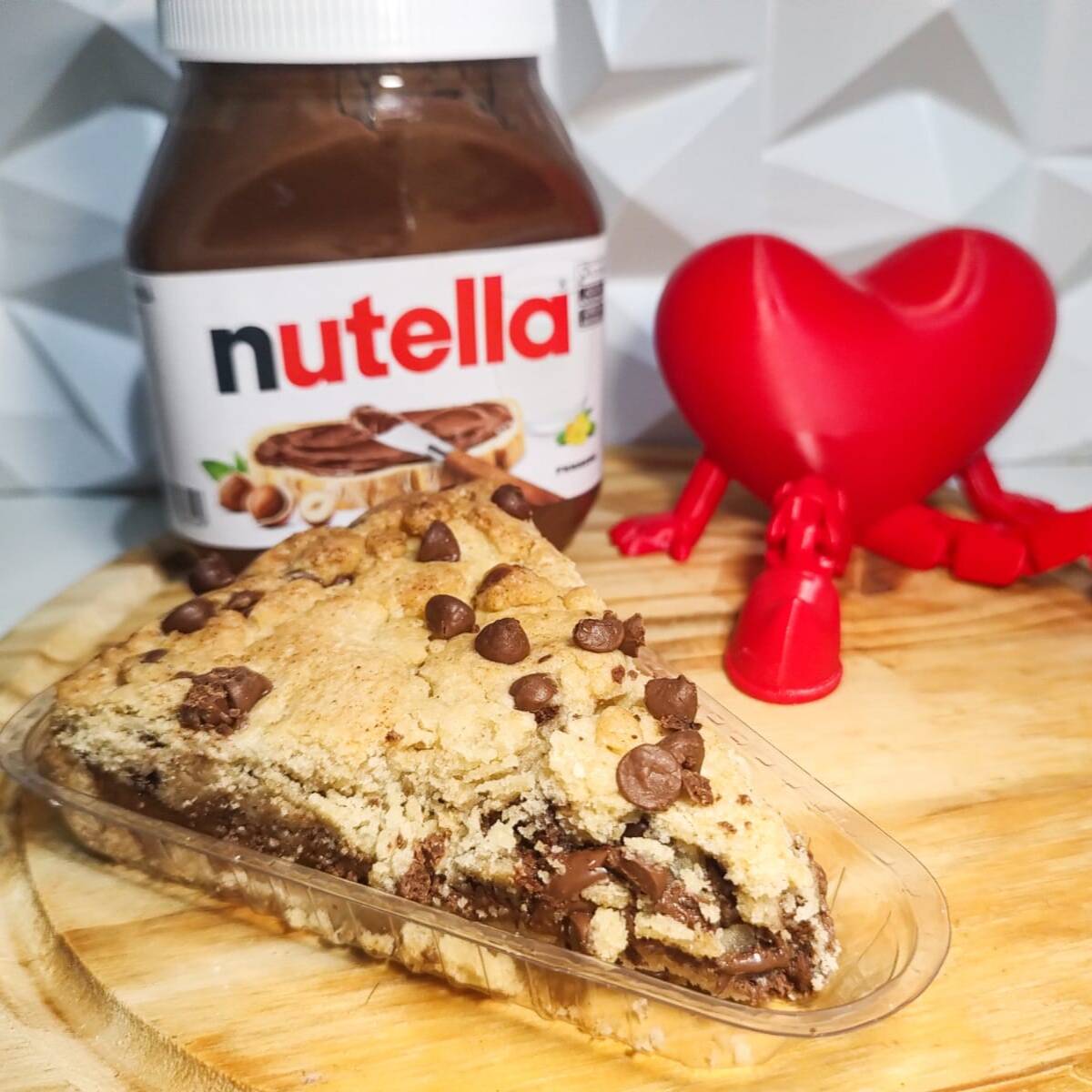Fatia de cookie com Nutella e gotas de chocolate: massa macia por dentro, levemente crocante por fora, recheio cremoso de Nutella e muitas gotas de chocolate. Uma fatia generosa para quem quer matar a vontade de doce sem pensar duas vezes.