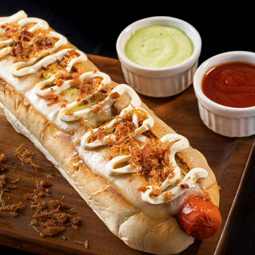 PÃO DE BATATA DE 30CM APROXIMADAMENTE, 2 SALSICHAS, KETCHUP,MOLHOS,CREAM CHEESE, BACON QUEIJO MUSSARELA MAÇARICADO.