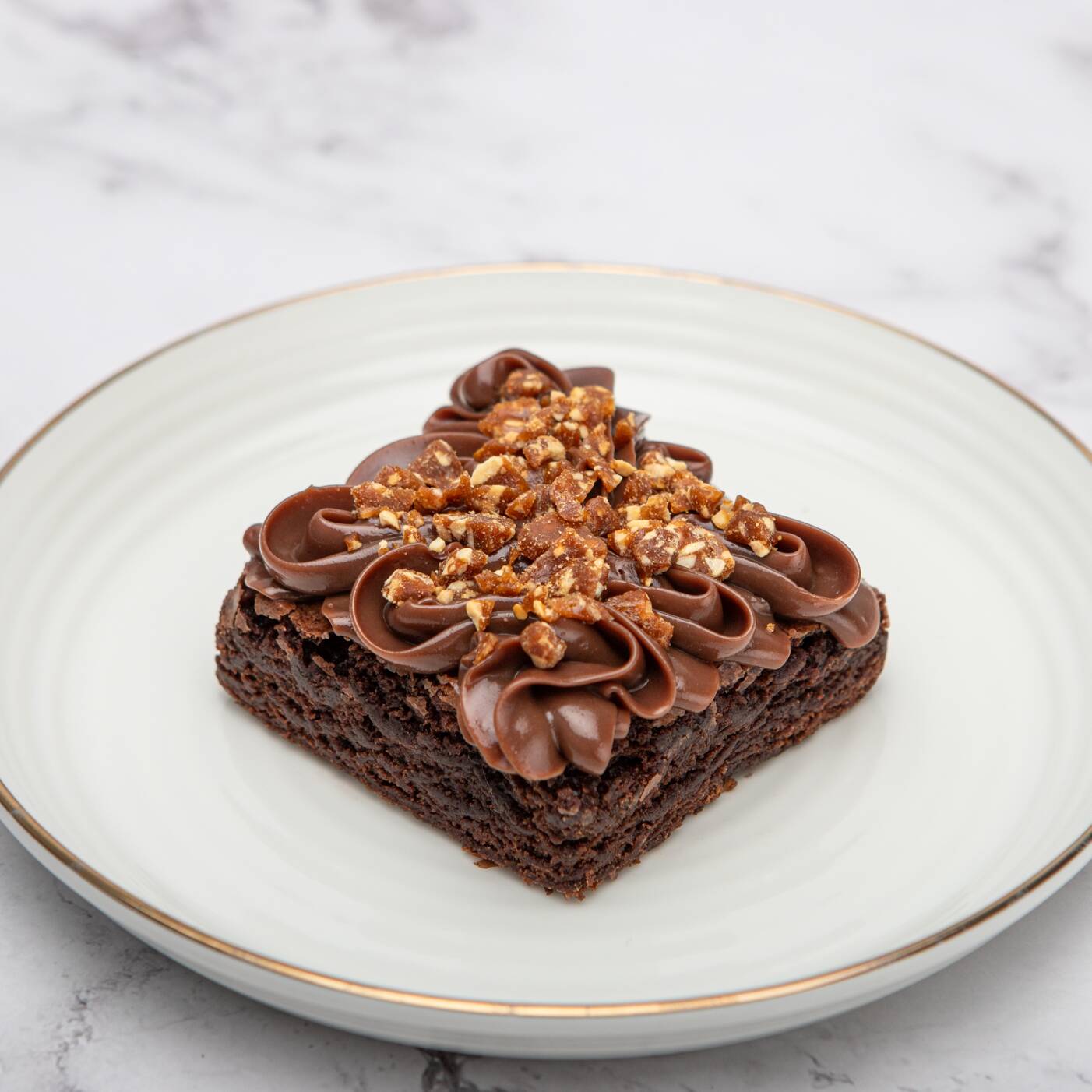 Brownie macio e intenso, coberto com brigadeiro meio amargo e finalizado com crocantes de amendoim.