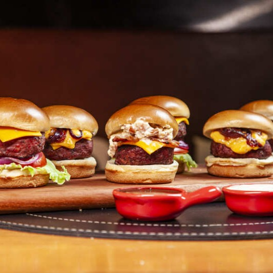 Uma explosão de sabores em miniatura! Experimente nosso Mini Burger Aperitivo, que traz 2 Mini Chevrolet Burgers com queijo cheddar, alface, tomate e cebola; 2 Mini Ram Burgers com bacon crocante e maionese de bacon; e 2 Mini Cheddar Burgers com molho cheddar e cebola caramelizada. Todos preparados com hambúrguer Angus e pão brioche, uma combinação perfeita para compartilhar!