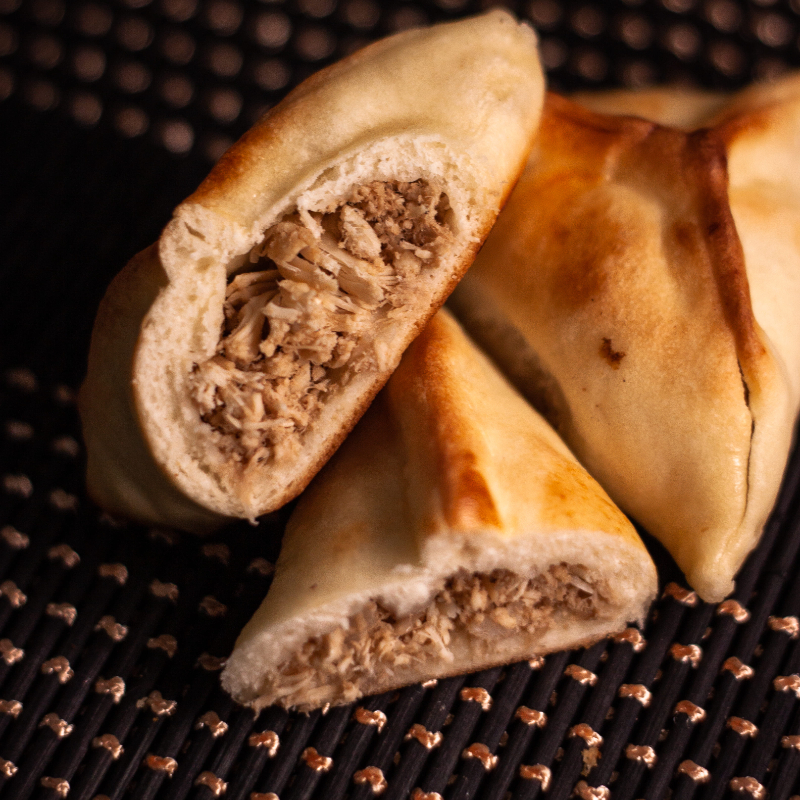 Massa artesanal macia e recheio de frango desfiado suculento com o tempero original da casa.