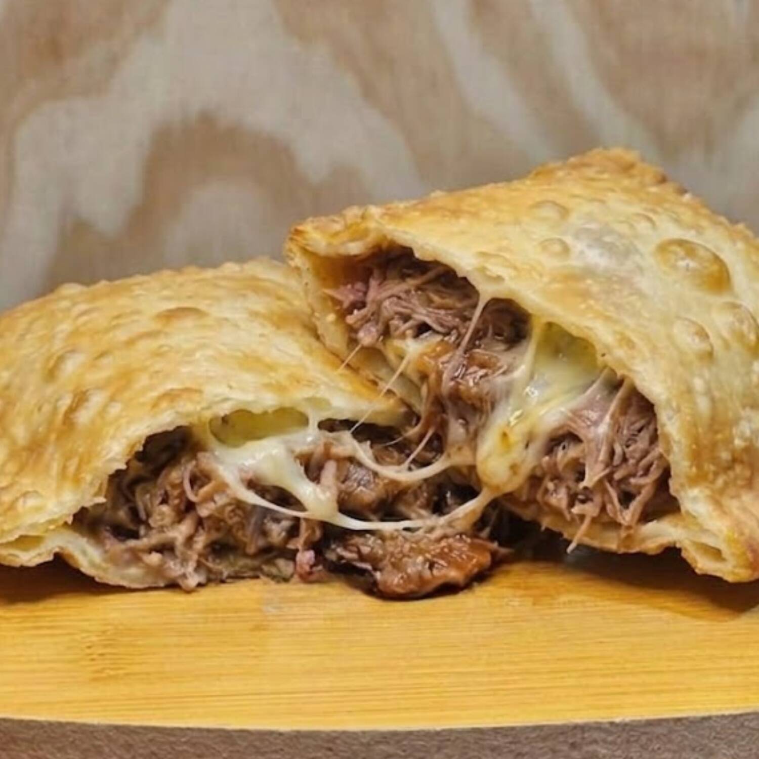 Delicioso pastel recheado com costelinha suína desfiada, queijo derretido e molho barbecue. Uma explosão de sabores irresistível.