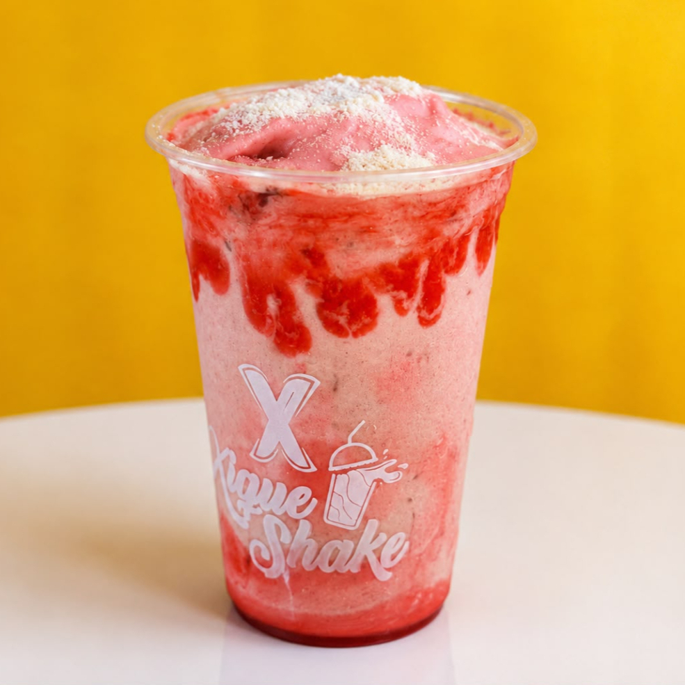 Desfrute do Shake Especial Xique Morango, famose mousse de morango com cobertura e calda de morangouma experiência doce e refrescante.