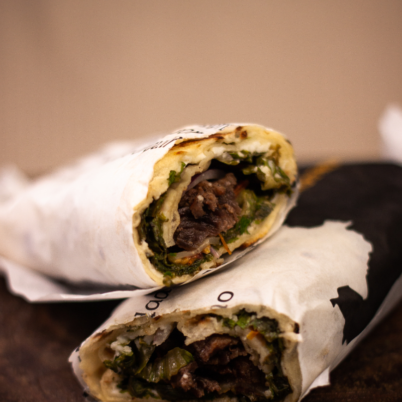 Enrolado no pão sírio com kafta, pasta de grão de bico ou alho, salsinha, cebola, picles, alface e tomate.