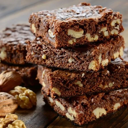 Intenso, úmido e irresistivelmente macio. Nosso brownie é preparado com chocolate de alta qualidade, proporcionando uma textura densa e aveludada, enriquecida com nozes selecionadas que acrescentam crocância e um sabor marcante. O equilíbrio perfeito entre a intensidade do chocolate e o toque amanteigado das nozes faz de cada pedaço uma experiência única e indulgente.