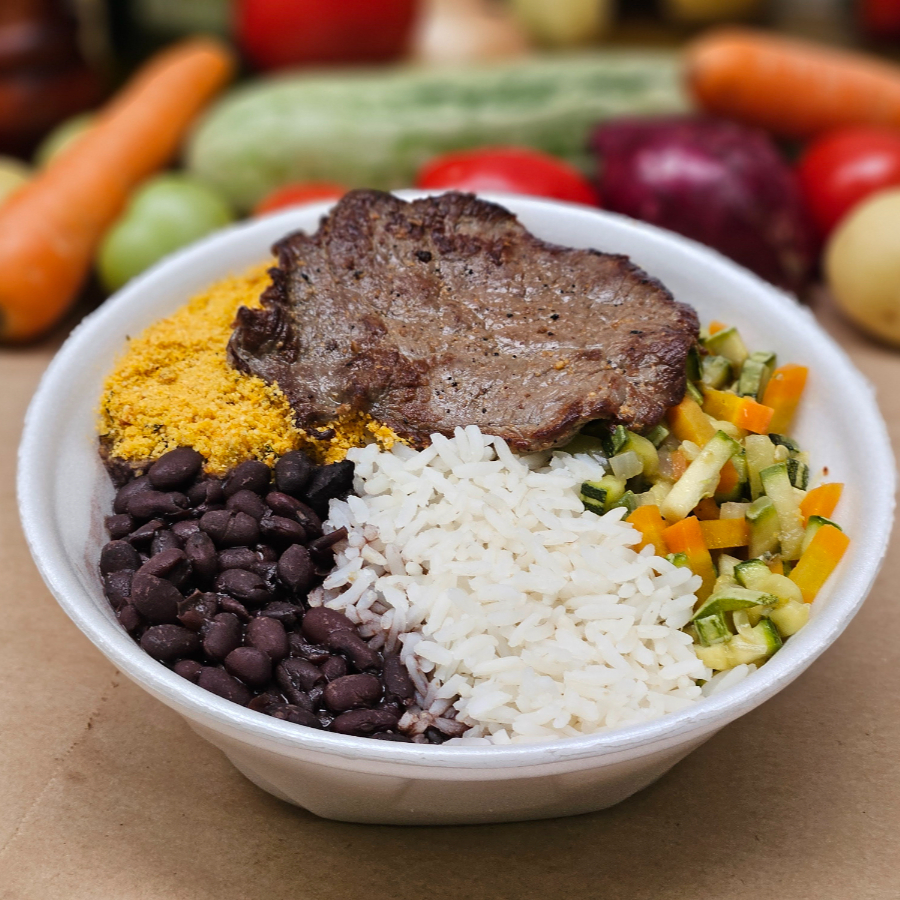 Nossa marmita média traz o melhor da culinária brasileira, com: - Arroz branquinho, - Feijãozinho temperado, - Legume da estação** - Farofa campeira crocante - Bife de coxão mole (aproximadamente 80 gramas). ** Os legumes que acompanham nossas marmitas podem variar conforme a estação e a qualidade disponível em cada período do ano.