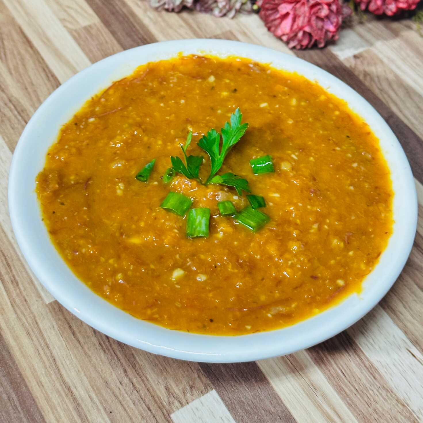 Cremoso, aveludado e irresistível. Nossa receita exclusiva combina a base nutritiva da abóbora com o sabor inconfundível da carne seca desfiada. O segredo? Um refogado caprichado de cebola roxa e alho, com o toque especial da páprica defumada que traz profundidade a cada gole. Finalizado com o frescor do coentro e cheiro-verde. Uma explosão de sabores afetivos em cada colherada.