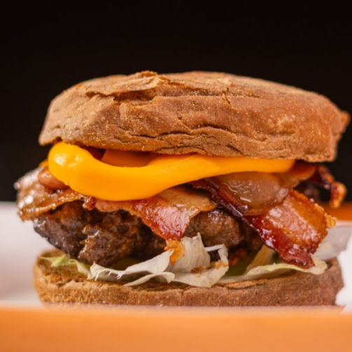 Feito com o delicioso Pão Australiano, Hambúrguer 150g Suculento de Costela, Cheddar Cremoso, Bacon Crocante, Alface e Tomate + Acompanhamento de Batata Frita150g.
