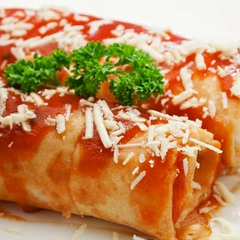 Panqueca de frango cremosa com molho de tomate caseiro, polvilhado de orégano e queijo derretido ! Um clássico que vai te fazer querer mais !.. *imagem ilustrativa*