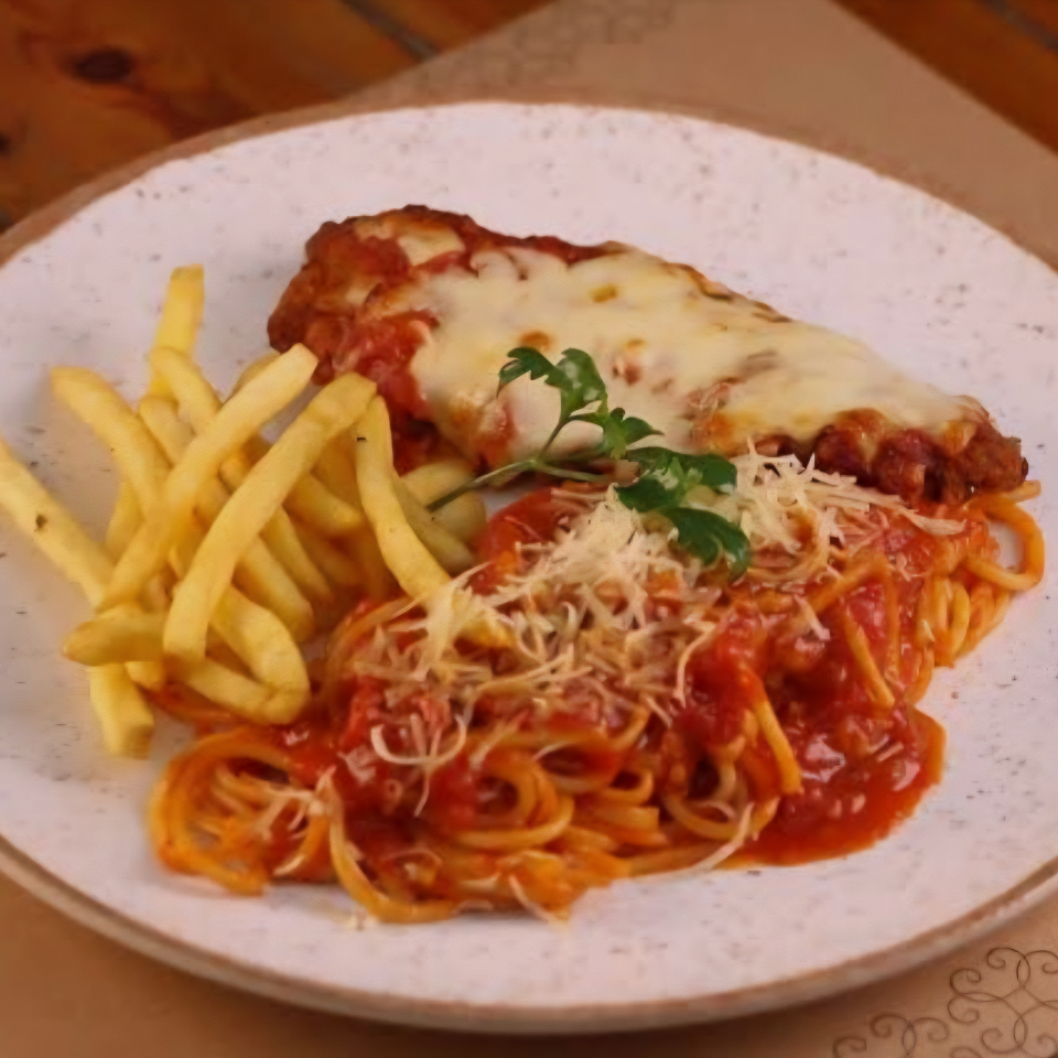 Delicioso file de frango empanado e coberto com queijo e molho de tomate acompanhado de Espaguete ao sugo e batata fritas
