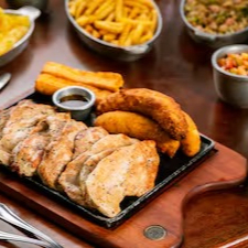 Frango Grelhado 800g in natura. Acompanha: Arroz branco, feijão tropeiro, batata frita, banana à milanesa, queijo coalho, paçoca de carne, mandioca cozida e vinagrete.