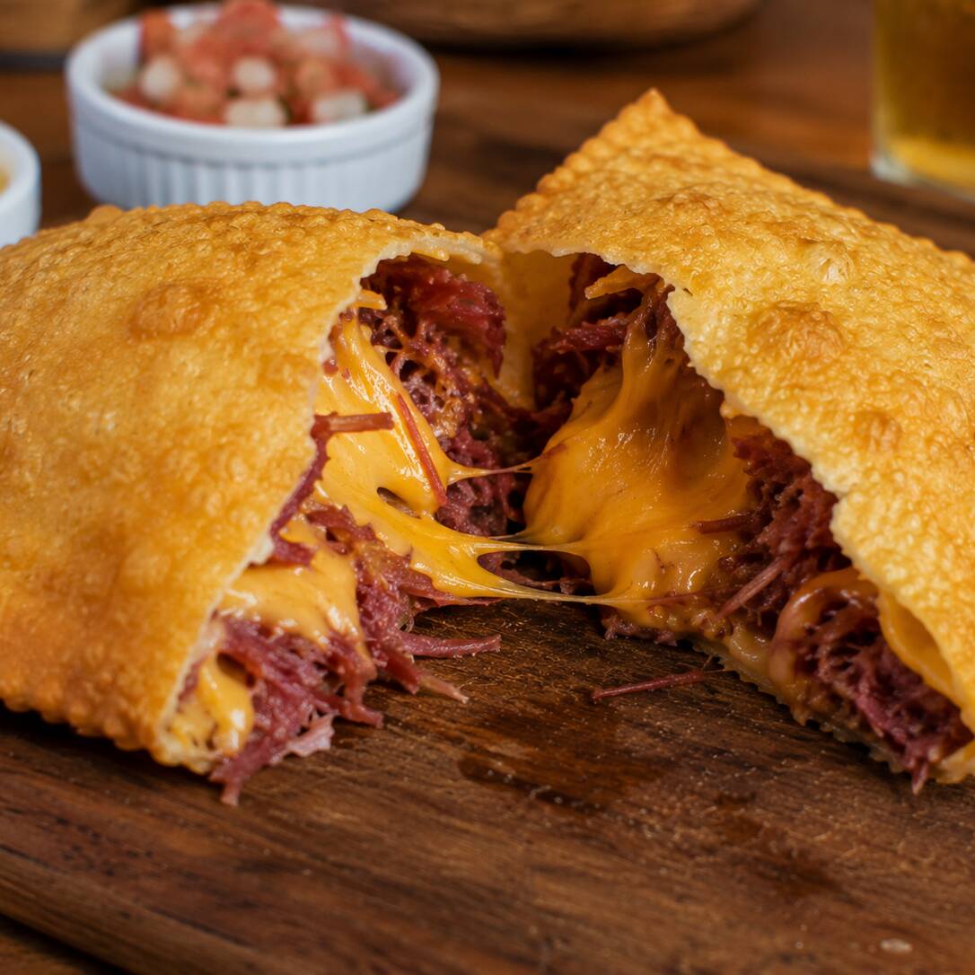 Carne seca desfiada e bem temperada, combinada com cheddar cremoso, formando um recheio intenso, cremoso e cheio de sabor. Tudo envolvido em uma massa sequinha, crocante e douradinha. Uma combinação irresistível para quem ama sabores marcantes! 🤤