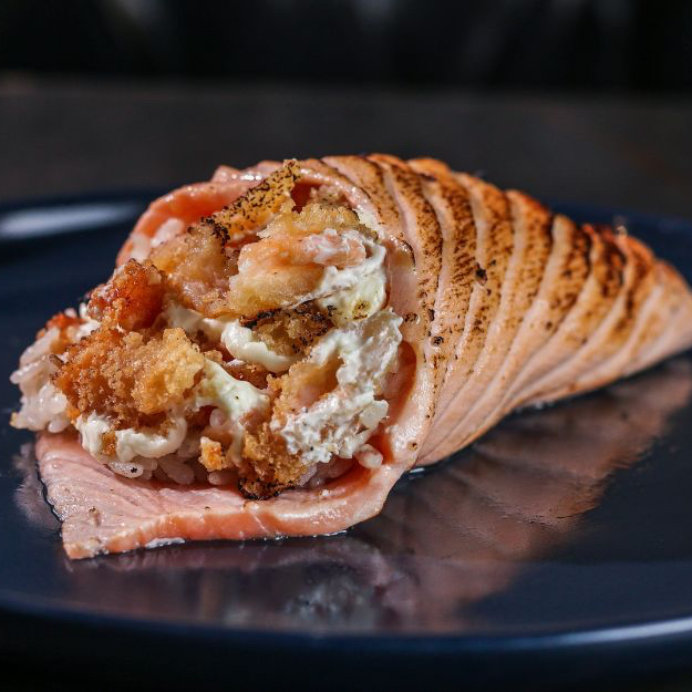 Camarão empanado, arroz japonês e cream cheese envoltos de filé de salmão maçaricado. Aproximadamente 300g.
Imagem ilustrativa.