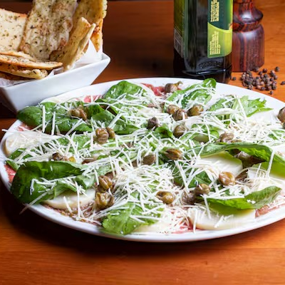 Carpaccio de carne coberto com palmito, rucula, alcaparas e parmesão e cesta de focaccia,