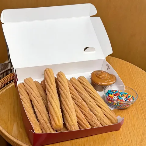 10 unidades de churros espanhóis: crocantes por fora, macios por dentro e finalizados com açúcar e canela. Acompanha 2 copos de 30ml de recheio à sua escolha e 1 copo de confeitos para personalizar como preferir. Aproximadamente 16cm cada unidade.
