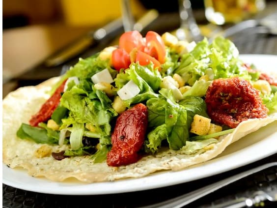 Alface americana, alface crespa, rúcula, queijo minas frescal, tomate seco, azeitonas pretas e croutons. Temperada com ervas e molho vinagrete balsâmico.