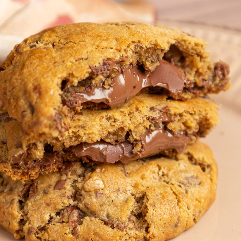 Massa cookie artesanal, recheado com nutella e pedaços de nozes.