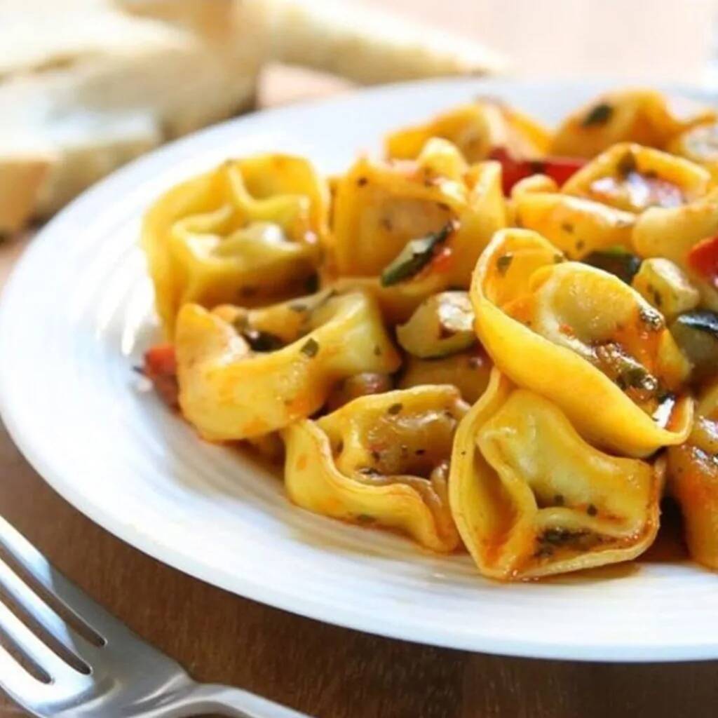 Mussarela ralada, massa de capelete e molho.