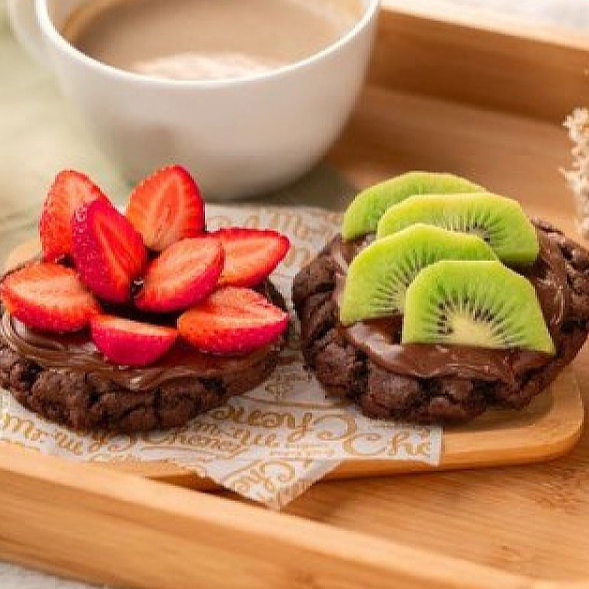 Cookie e frutas? Deu match. Cookie Clássico da sua preferência coberto com creme de avelã e frutas da estação. É fit, vai.