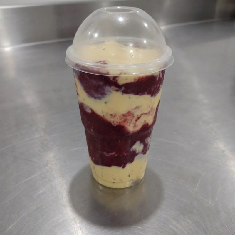 Açaí batido com morango, completado com camada mousse de maracujá e camada de chocolate. Copo de 300ml. Imagem Ilustrativa.