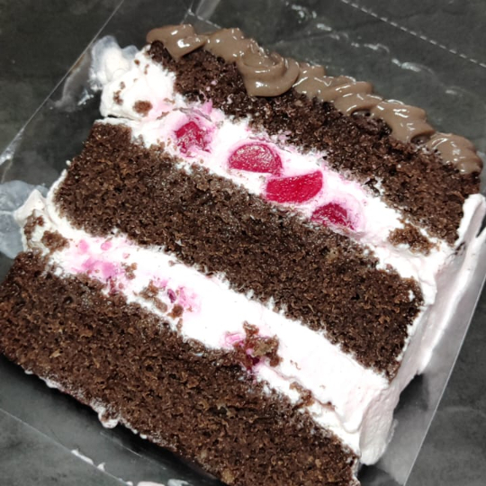 Fatia de bolo floresta negra feito com massa de chocolate, recheio de chantilly e ágar ágar (gelatina vegetal), finalizado com recheio de brigadeiro de chocolate