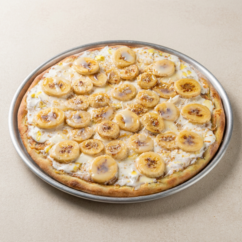 Nossa massa artesanal doce é coberta com creme de leite cremoso, chocolate branco derretido, banana fatiada e coco ralado, finalizada com um toque de leite condensado. (4 fatias)