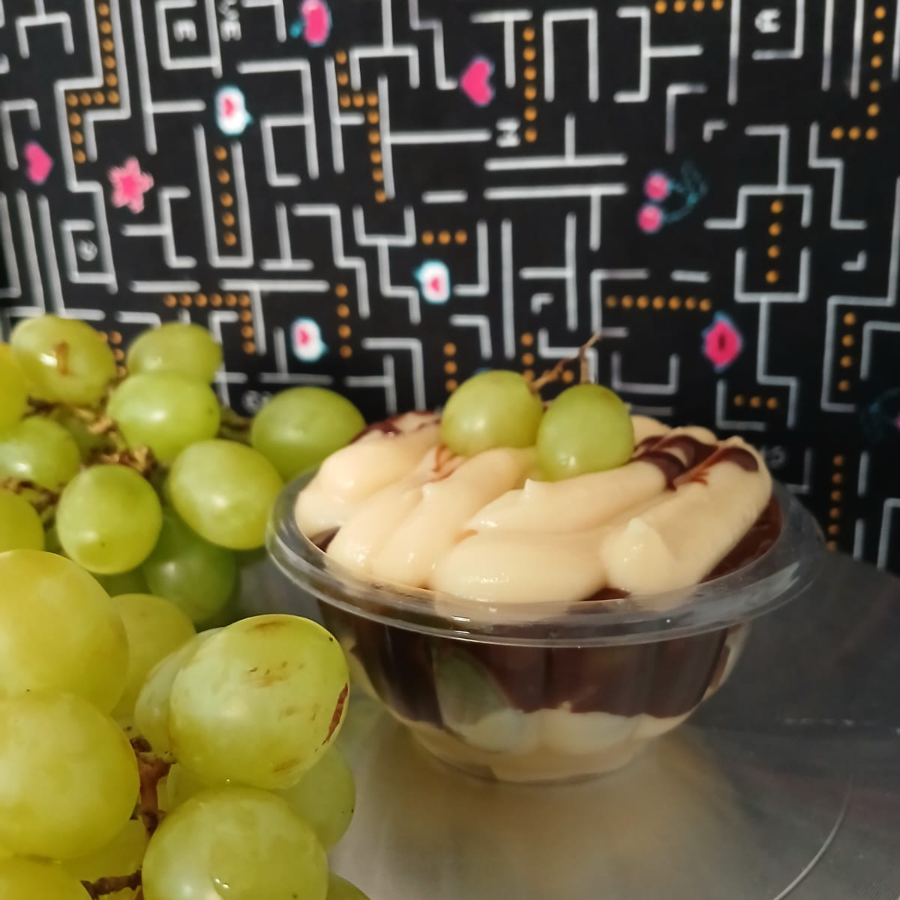 Uvas frescas e suculentas envolvidas em um creme suave de leite Ninho, cobertas por brigadeiro tradicional e uma camada delicada de creme de chocolate.
