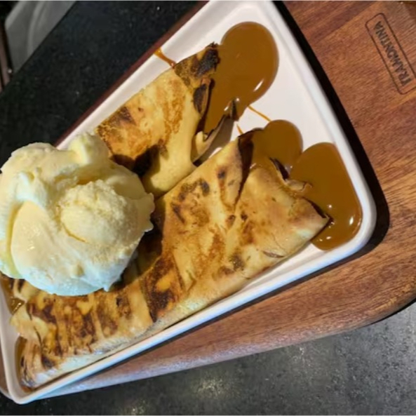 A 'Panqueca Uruguaia' é uma sobremesa verdadeiramente irresistível. A massa, feita de maneira artesanal, abriga um recheio generoso de doce de leite autêntico. A panqueca é então caramelizada na parrilla, o que lhe confere um sabor único e irresistível. Para finalizar, acompanha um cremoso e delicioso sorvete de creme. Um prato sofisticado, que aguça todos os sentidos e proporciona uma experiência gastronômica incrível, evocando o autêntico sabor do Uruguai!