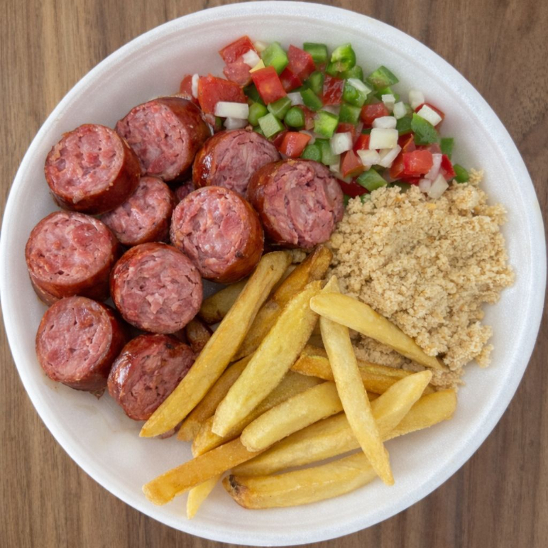 Acompanha arroz branco, feijão preto, farofa, vinagrete, batata frita e linguiça toscana