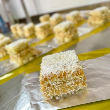 Massa de coco fofinha e bem molhada, recheada com doce de leite cremoso com coco em flocos