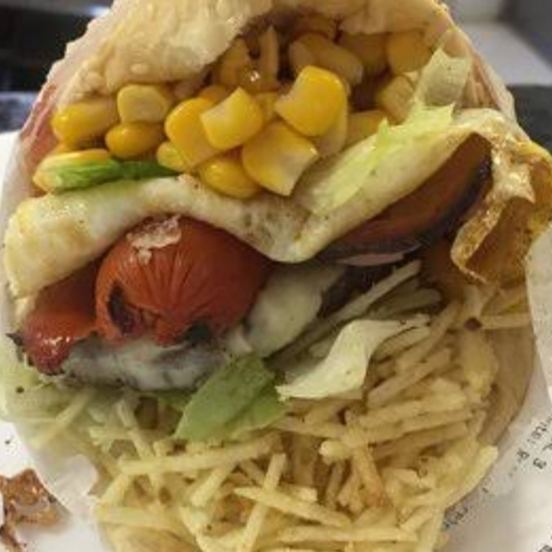 Pão, Hambúrguer, Mussarela, Apresuntado,Ovo, Tomate, Alface, Milho e Batata Palha.