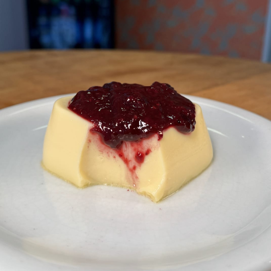 Pudim cremoso de chocolate branco com calda artesanal de frutas vermelhas, uma combinação doce e levemente ácida que derrete na boca. Serve 1 pessoa. Aproximadamente 150g.