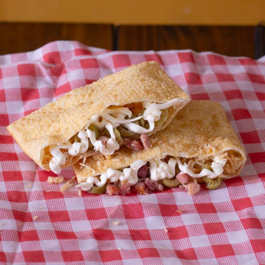 Delicie-se com o nosso Pastel de Frango, Catupiry e Milho! Este autêntico prato brasileiro apresenta uma combinação perfeita de sabores. Aprecie o frango desfiado, suculento e bem temperado, harmonizado com o Catupiry, que traz uma cremosidade inigualável e deixa o pastel ainda mais saboroso. O milho adiciona uma leve doçura que contrasta perfeitamente com os outros ingredientes. A massa é macia por dentro e crocante por fora, proporcionando uma experiência sensorial incrível. O pastel tem um tamanho generoso, aproximadamente 20x15cm. Uma obra-prima dos pastéis especiais, recheada de amor e sabor!