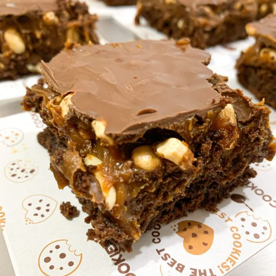 Brownie com recheio de caramelo, amendoim e chocolate ao leite. Aprox 120g