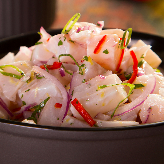 Experimente o ceviche, peixe marinado ao molho cítrico e picante, uma explosão de sabores frescos e vibrantes.