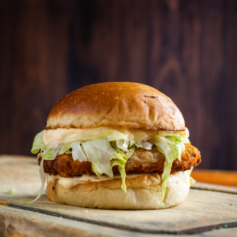 Pão macio, hamburguer de frango empanado e frito na hora, alface fresca e molho da casa .