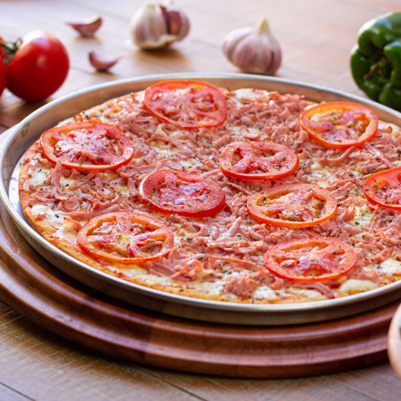 Molho de tomates, queijo mussarela, presunto desfiado, tomate e orégano.