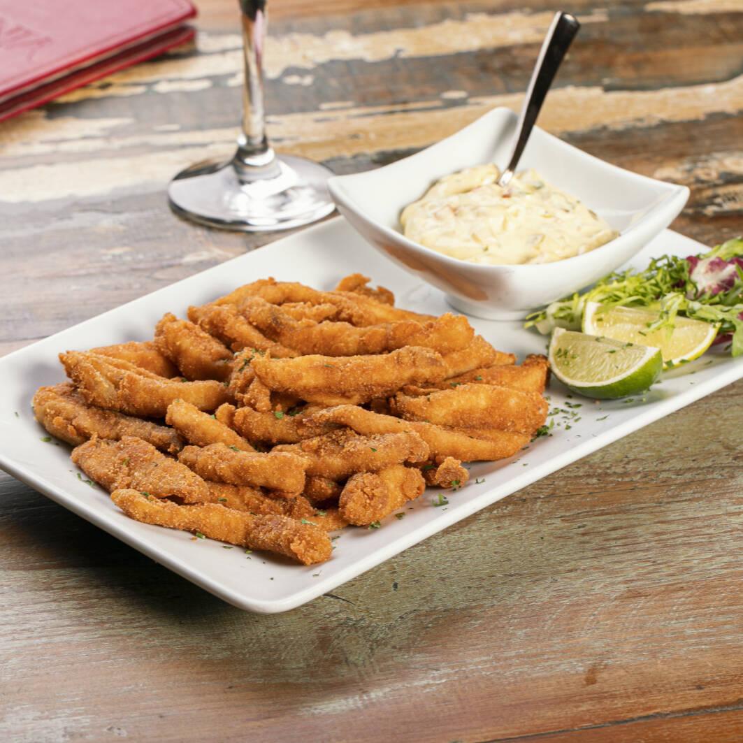 Iscas de tilápia à milanesa ou à romana, servidas com o molho tártaro da casa.