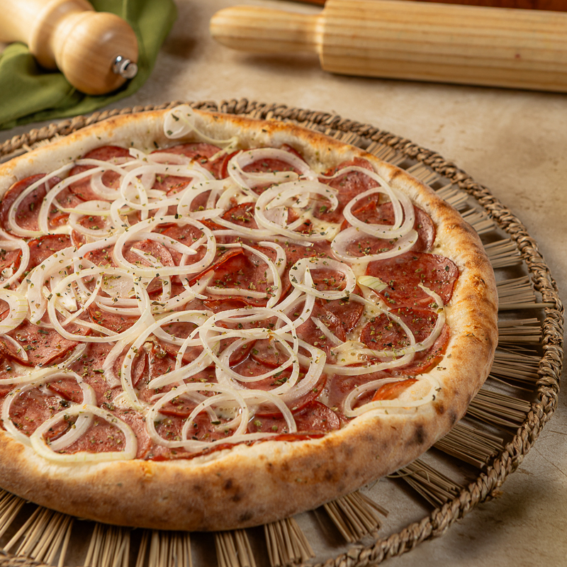Na pizza de calabresa vai : Molho de tomate, queijo ralado mussarela, calabresa fatiada cebola, e orégano