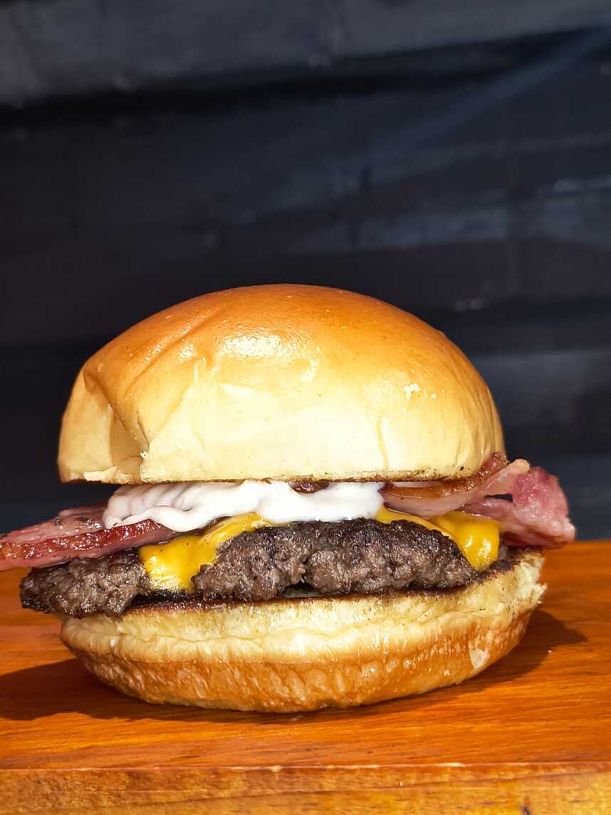 Um smash de 70g acompanhado por , bacon , fatia de queijo cheddar derretido e a nossa deliciosa maionese de bacon .