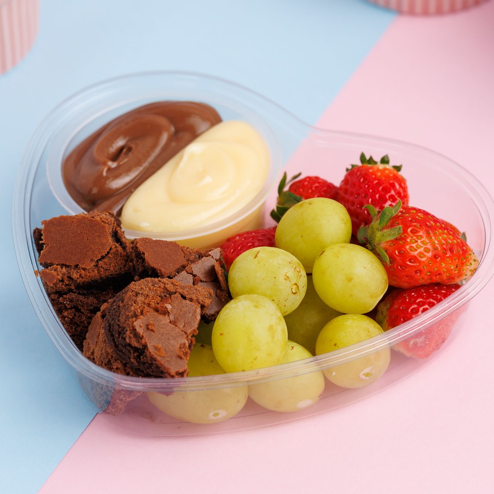 Fondie individual acompanha uvas verdes sem semente , morangos e pedaços de brawnie junto com uma combinação de creme de Ninho e chocolate