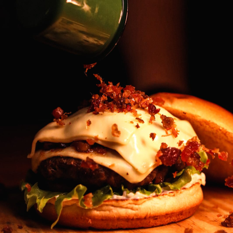 Hambúrguer 160g Coberto com Muçarela + Bacon Granulado Caramelizado + Muçarela + Bacon, Alface Crocante, Tomate e Molho Defumado! Um Burguer Suculento com Vários Sabores.