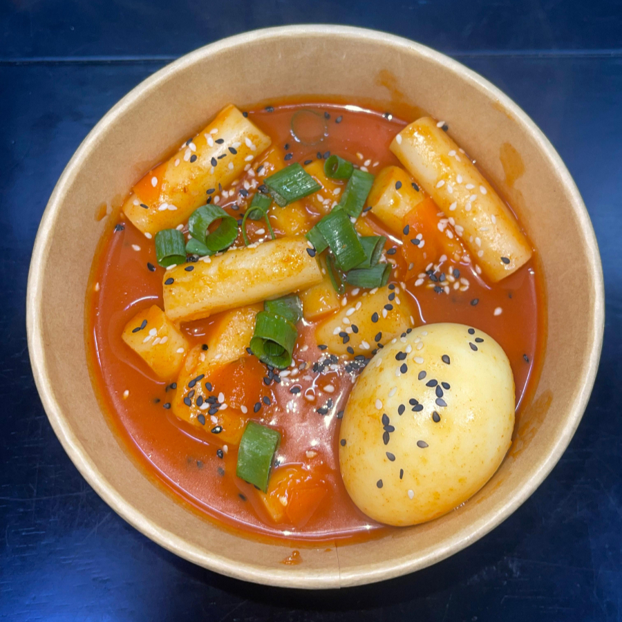 Bolinhos cilíndricos de arroz temperado com a pasta de pimenta, Gotchujang, legumes, cebolinha e ovo.