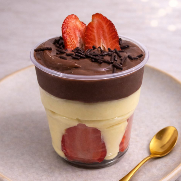 Uma deliciosa camada de creme de ninho com morangos frescos e creme de chocolate 50% e finalizado com morango e granulé ao leite