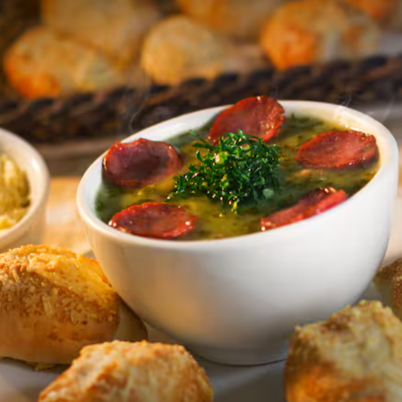 Delicie-se com o nosso Combo Sopa Caldo Verde + 4 Mini Pães Parmesão + Pote Parmesão. Esse prato é uma verdadeira experiência culinária invernal. A sopa Caldo Verde é feita com batatas suavemente cozidas, couve fresca e crocante, cebola dourada e linguiça, perfeitamente equilibrada em sabores. Acompanha quatro irresistíveis mini pães de parmesão, quentinhos e crocantes, e um delicioso pote de parmesão ralado na hora para você adicionar a gosto. Ideal para aquecer suas noites frias de inverno, tornando-as mais aconchegantes e saborosas. Não resistirá a essa combinação perfeita!