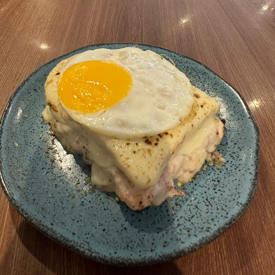 Pão, molho bechamel, queijo, presunto e ovo.