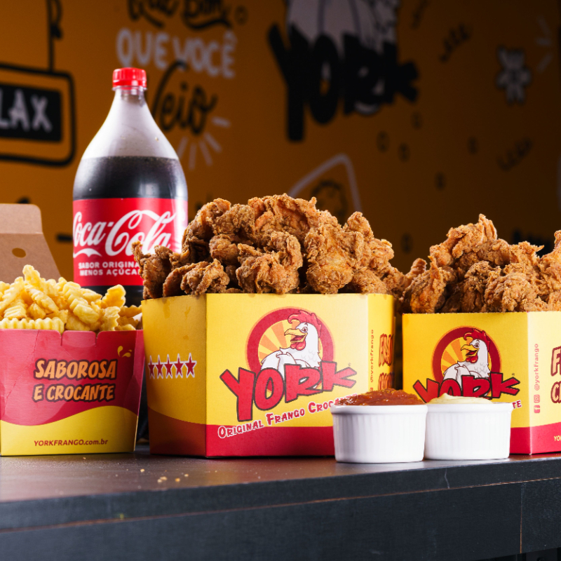 Você leva 1 Balde Box Grande 900g + 1 Balde Box Médio 450g do seu corte preferido + 1 Porção Grande 400g de Batata/ ou Polenta/ ou Mandioca + 1 Refrigerante 2l + 2 Molhos Artesanais da sua escolha. Serve de 4 a 6 pessoas. Foto ilustrativa.